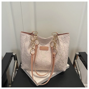 Close-up of star-quilted texture on light pink tote bag with gold chain strap detail