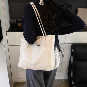 Elegante borsa tote in pelle martellata bianco crema da donna indossata a spalla