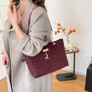 Large burgundy leopard embossed tote bag with gold deer charm and chain strap