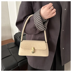 Détail du sac bandoulière crème avec motif léopard embossé et fermoir doré rotatif