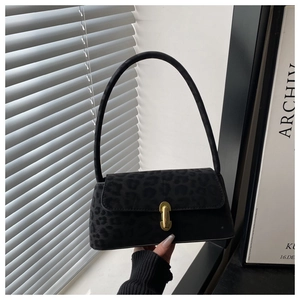 Close-up of black leopard print textured underarm bag with elegant gold metal lock