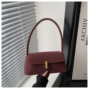 Detail of burgundy baguette bag with subtle leopard embossing and gold clasp closure