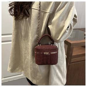 Macro detail of burgundy leopard print crossbody box bag with gold chain and top handle