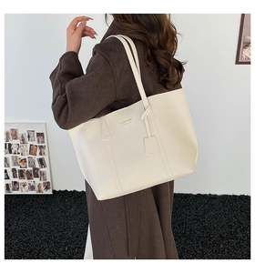 Close-up of cream tote bag with gold lettering and premium leather texture for women