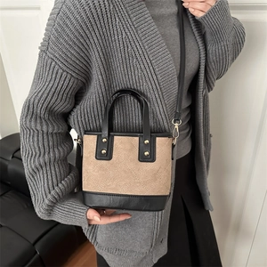 Sac seau vintage en daim beige surpiqué avec finitions en cuir noir et rivets dorés