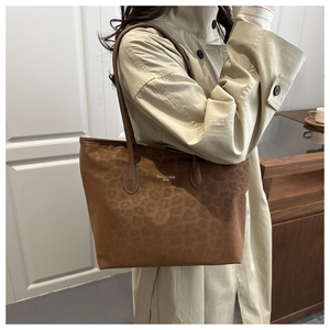 Close-up of leopard print tote bag with gold logo lettering on premium matte fabric