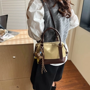 Vintage beige canvas and brown leather pillow bag with bear charm on a model