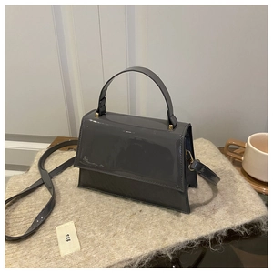 Détail du sac à main gris anthracite en cuir verni avec finition brillante et dorures