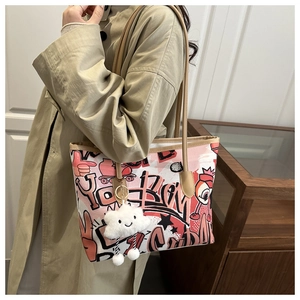 Detail of artistic graffiti tote bag with pink canvas and plush cloud charm accessory