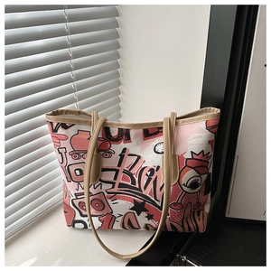 Detailed view of canvas tote bag featuring pink graffiti art and faux leather straps