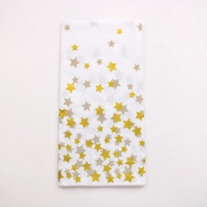 Detail of thickened rectangular tablecloth with gold and gray star patterns on white base