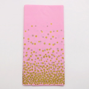 Detail of pink disposable tablecloth with metallic gold polka dots for party decoration