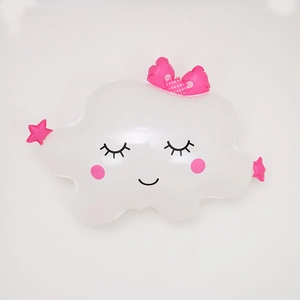 Détail de ballon nuage en aluminium avec visage souriant, nœud rose et étoiles décor