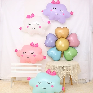 Détail de ballons nuages souriants et décor de fleurs en cœur colorées en aluminium