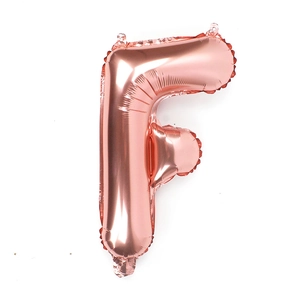 Detail of rose gold foil balloon in letter F shape with metallic finish for parties