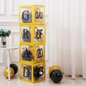 Detail of 4 gold transparent boxes with black and gold balloons for graduation decor