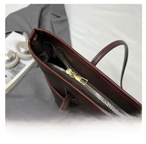 Detailaufnahme des goldenen Reißverschlusses an der dunkelbraunen Leder-Tote-Bag