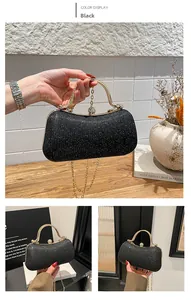 Detail of black glitter evening bag with gold curved handle and spherical clasp