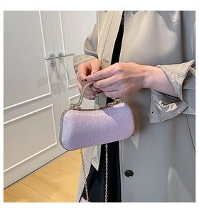Close-up of a light purple glitter clutch bag with gold handle and chain shoulder strap