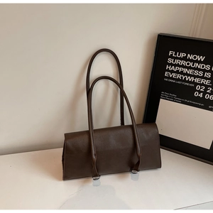 Detail of dark brown leather shoulder bag showing the minimalist finish and silver buckles