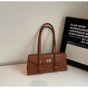 Detail of vintage brown matte leather pillow bag with silver buckle and twist lock