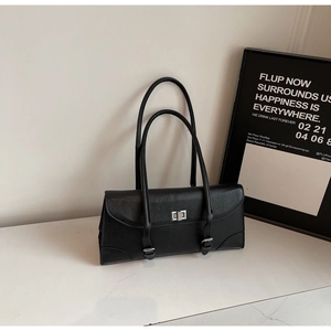 Close-up of black retro pillow bag with silver metal swivel lock and double shoulder straps