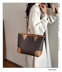 Close-up of contrast stitching and pebble leather detail on a large brown tote bag