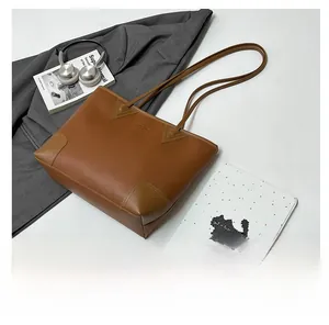 Detail of dark brown leather tote bag with unique triangle accents and reinforced corners