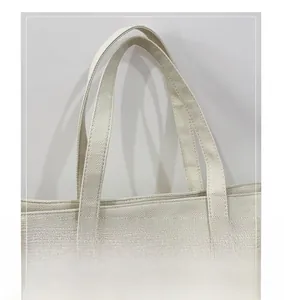 Détail des doubles poignées renforcées sur un sac fourre-tout épais en lin et coton