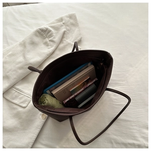 Spacious interior of dark brown leather tote bag showing large storage for daily essentials