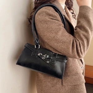 Retro black leather underarm bag with decorative metal buckle straps on model