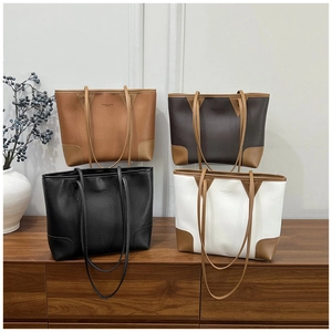 Detail view of stylish tote bags in four colors on a vintage wooden cabinet