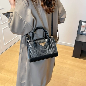 Vintage gray snakeskin pattern crossbody bag with golden hardware shown in a lifestyle view
