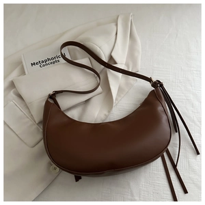 Détail du sac demi-lune marron foncé en similicuir lisse avec rubans latéraux élégants