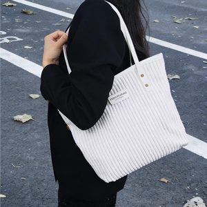 White corduroy tote bag with large capacity for women shown in a lifestyle outdoor setting