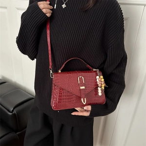 Borsa a tracolla rosso scuro effetto coccodrillo con fibbia dorata e ciondolo a perline