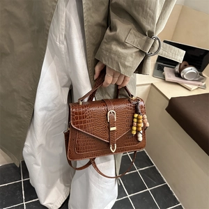 Borsa a mano marrone coccodrillo con ciondolo boho e tracolla regolabile