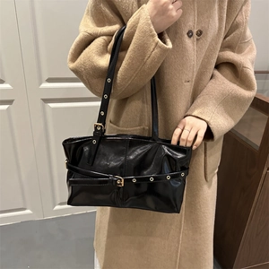 Minimalist black glossy leather underarm tote bag with golden eyelet strap and buckles