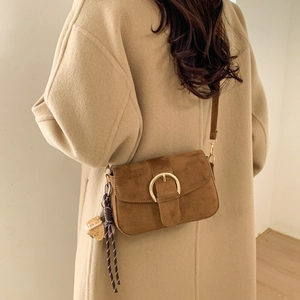Brown suede underarm bag with gold buckle and strawberry charm shown on model