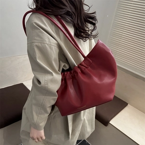 Red pleated cloud tote bag with thin straps shown on model for high-end fashion look