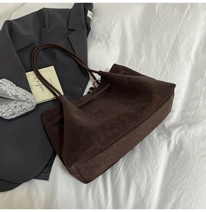 Deep brown faux suede tote bag with slim shoulder straps styled with aesthetic props