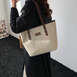 Minimalist beige tote bag with coffee leather trim and spacious commuter design