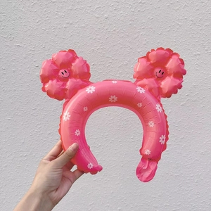 Pink inflatable daisy headband with smiley face flowers and white floral patterns