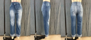 Détail de la taille haute croisée et du jean droit bleu délavé avec finitions usées