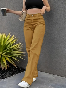 Detail of high waisted ginger yellow wide leg jeans with metal button and pockets