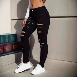Jean skinny noir pour femme avec déchirures et boucles métalliques style urbain