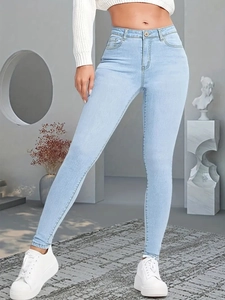 Détail d'un jean skinny taille haute bleu clair avec design classique à cinq poches