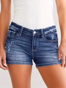 Detail shot of distressed blue denim shorts featuring washed texture and frayed edges