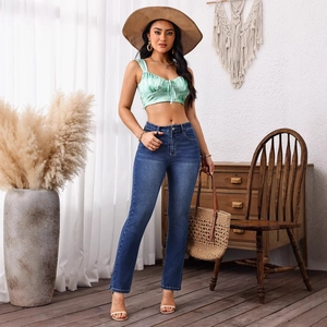 Detail of high waisted skinny jeans paired with a mint green satin crop top for a casual look