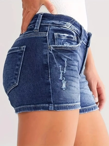 Detail showing distressed blue denim texture and ripped hem on slim fit casual shorts